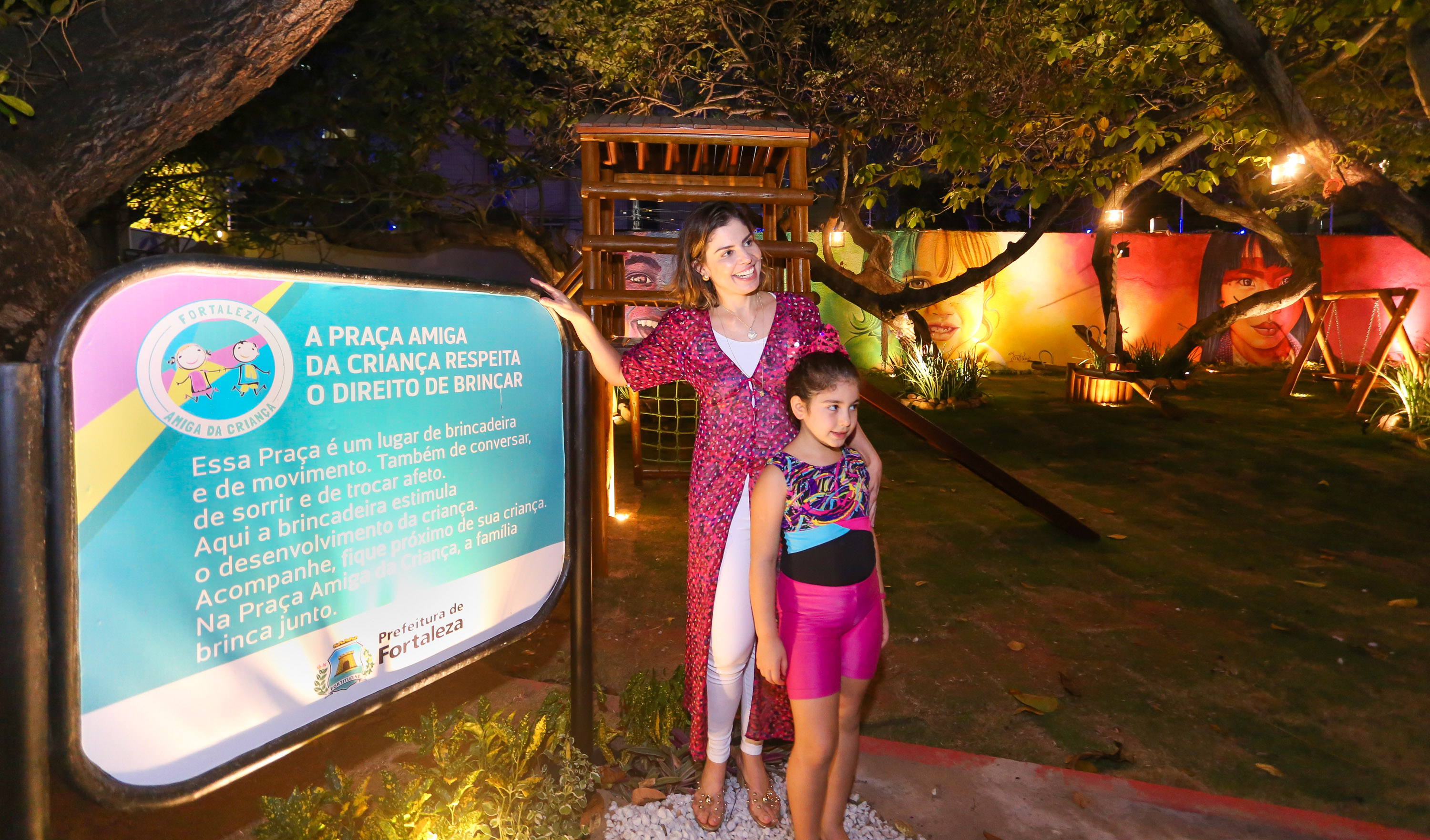 primeira-dama carol bezerra posa ao lado da placa da praça amiga da criança